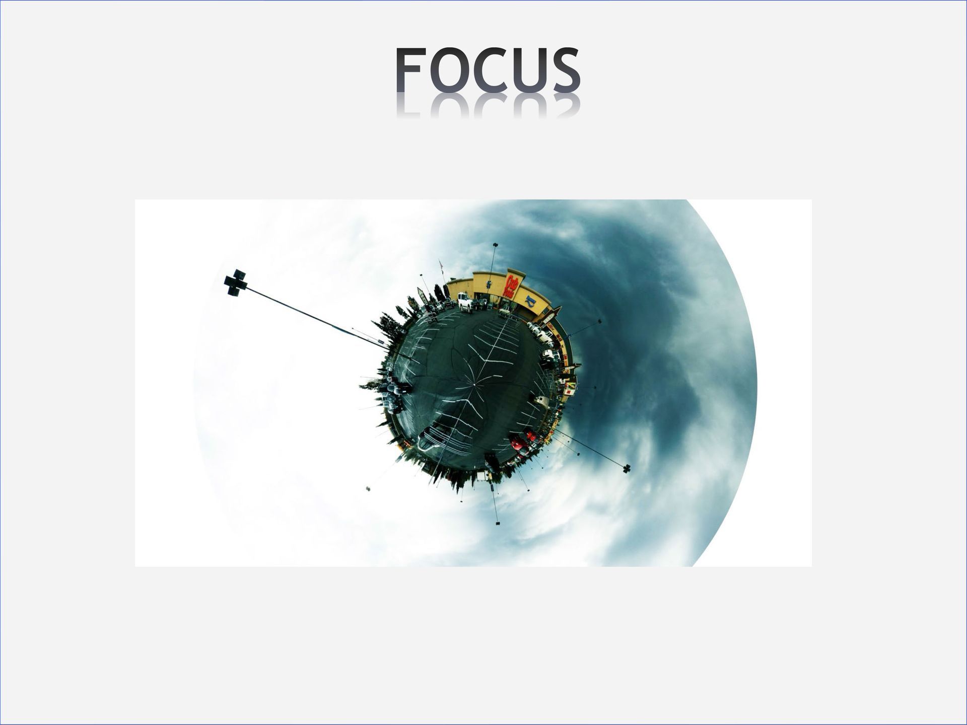 Small planet-like image with buildings and antenna in space against a cloudy sky. 