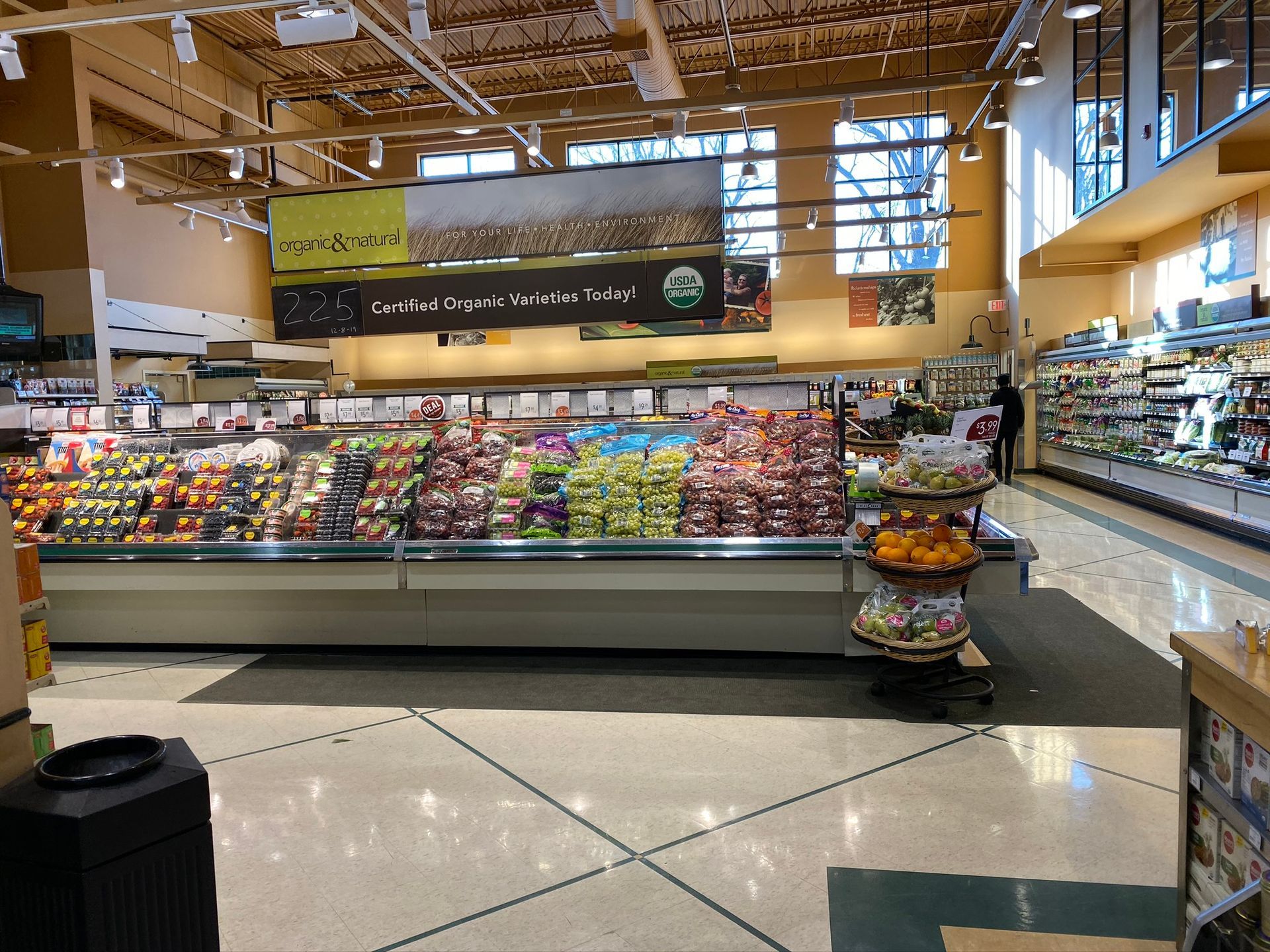 Grocery store produce section with various fruits and vegetables.
