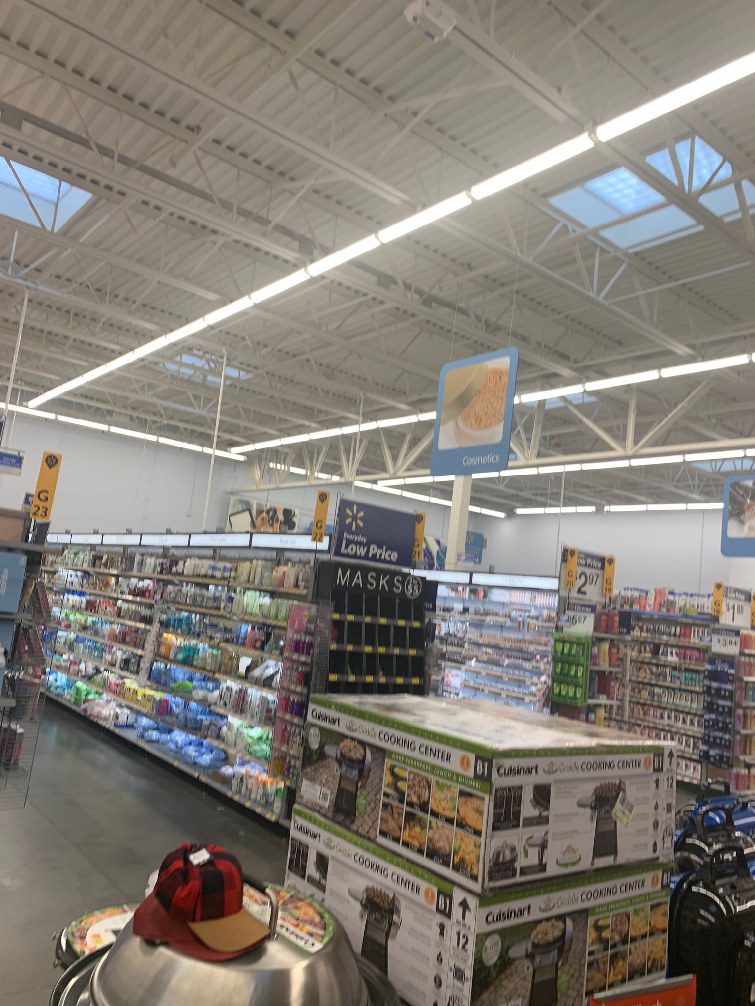 Inside a Walmart store, aisles with shelves of products, overhead lighting, and ceiling.