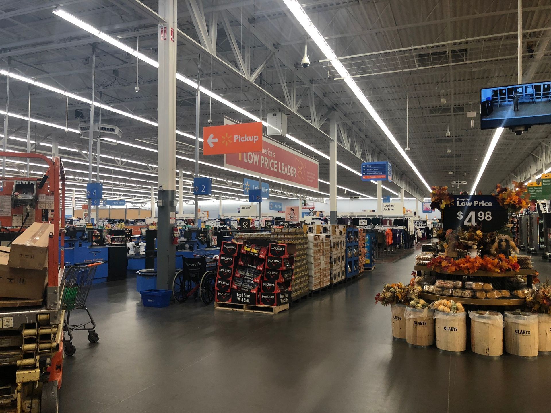 Inside a Walmart, showing aisles of merchandise, signs for 