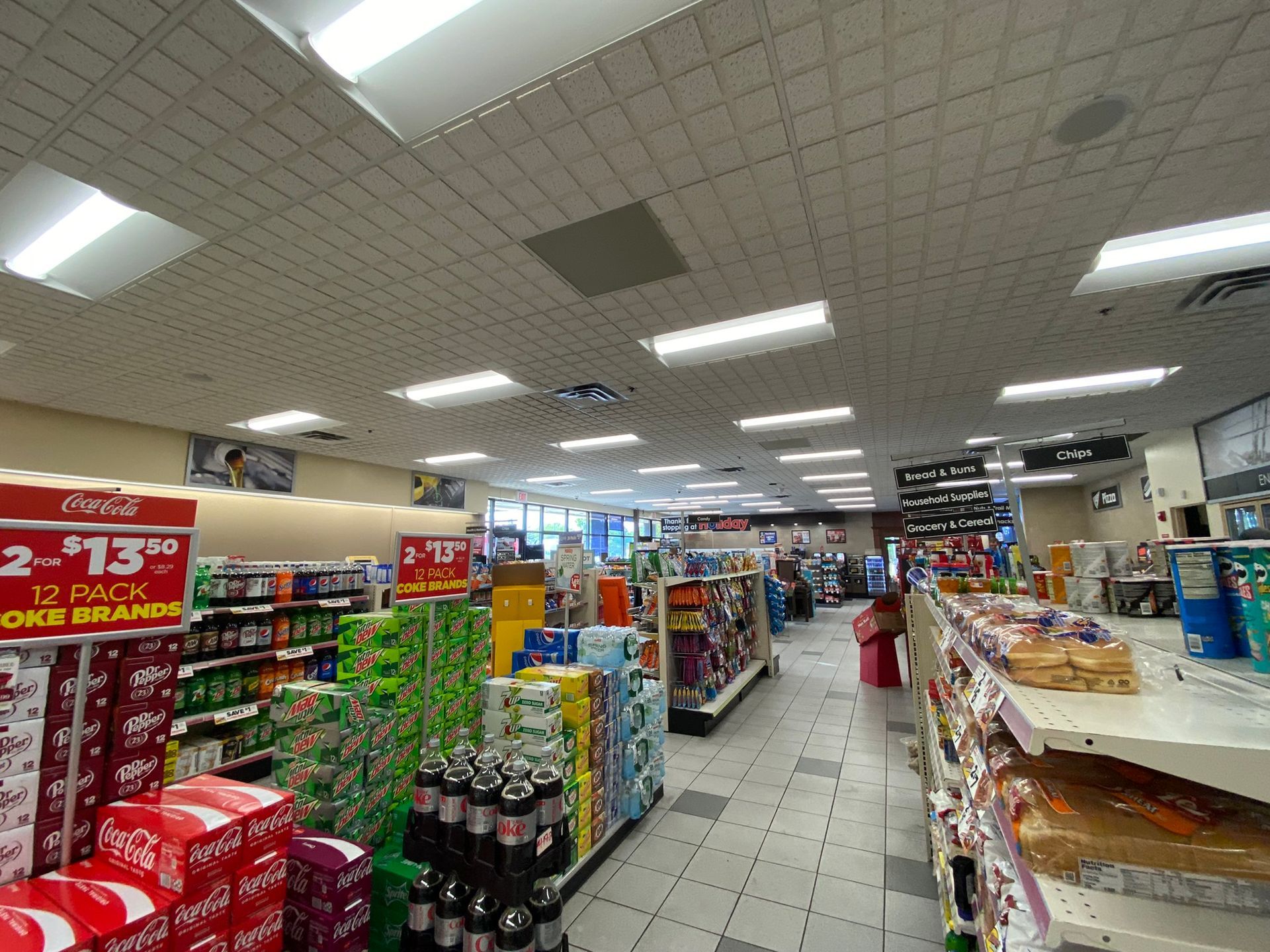 Interior of a convenience store, aisles lined with shelves of products, bright fluorescent lighting.