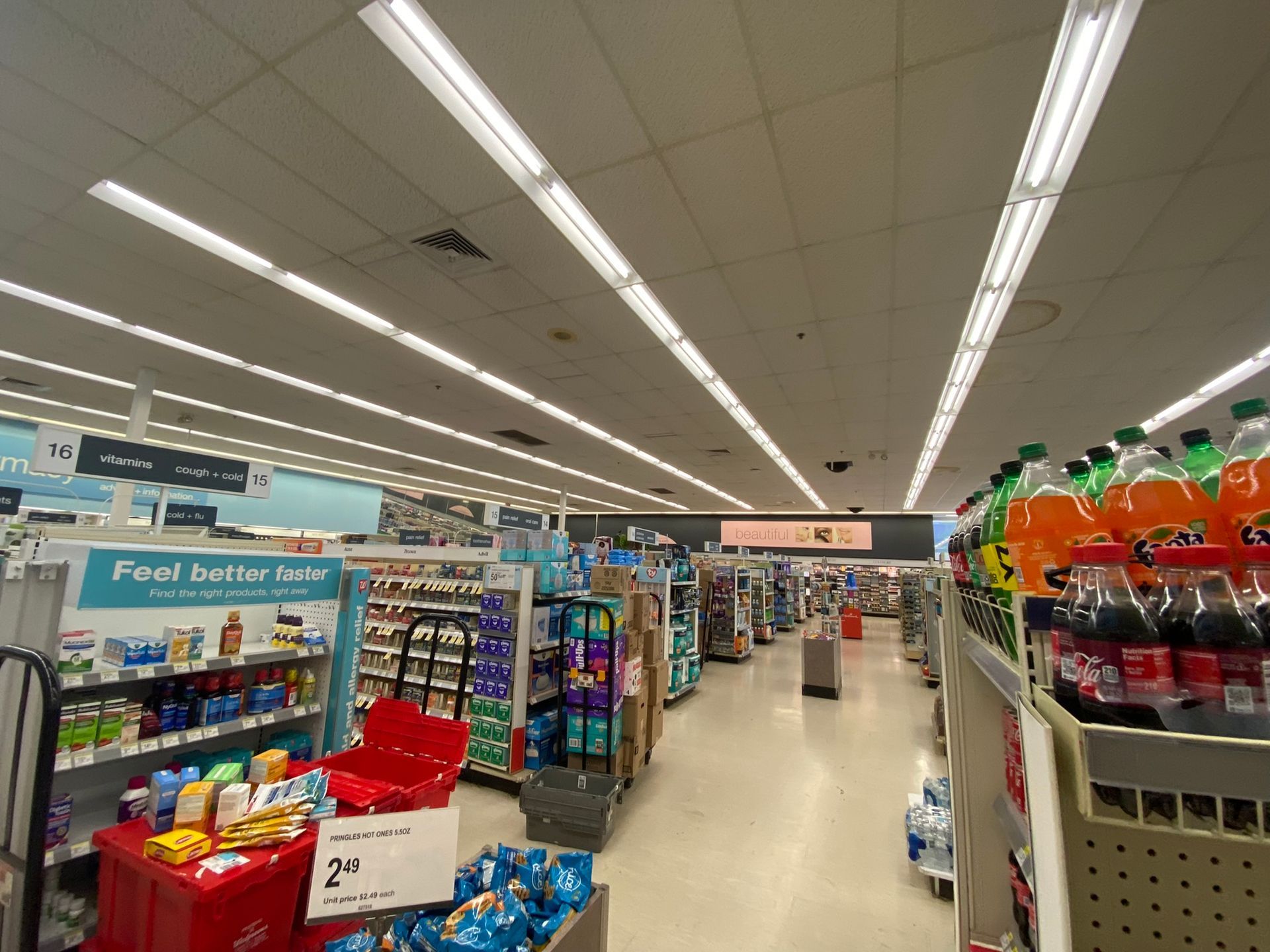 Interior view of a well-lit drugstore aisle lined with shelves of products.