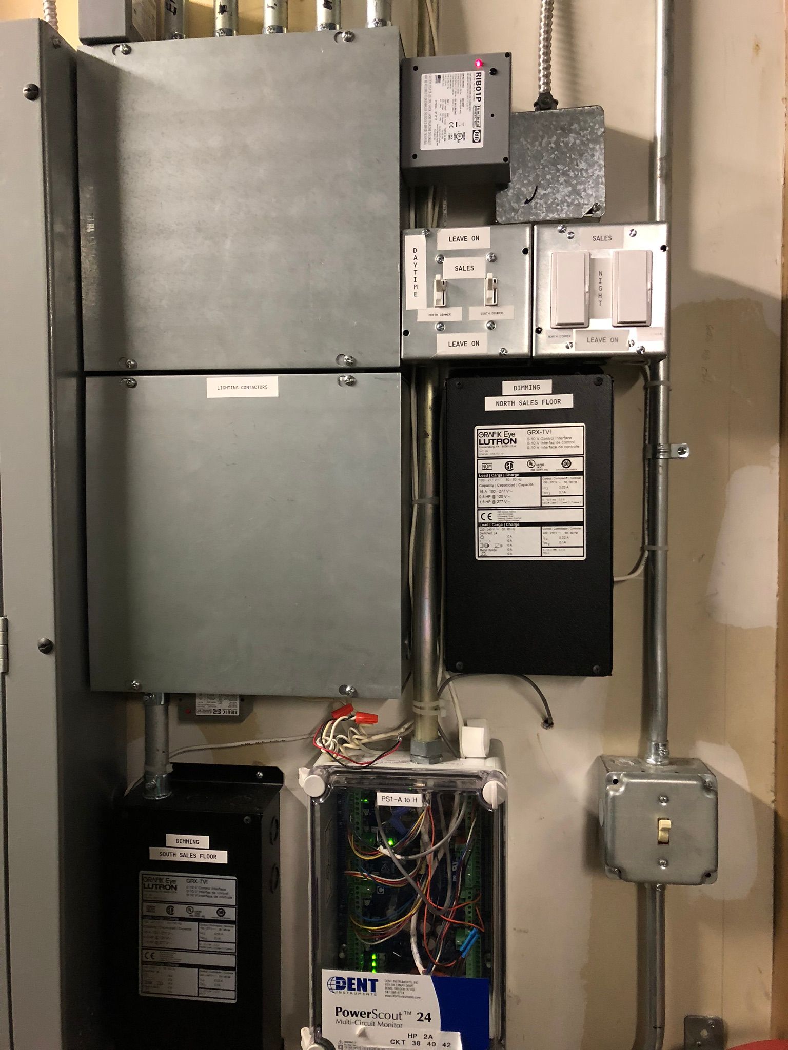 Electrical panels and wiring mounted on a wall. Includes conduit, boxes, and control components.