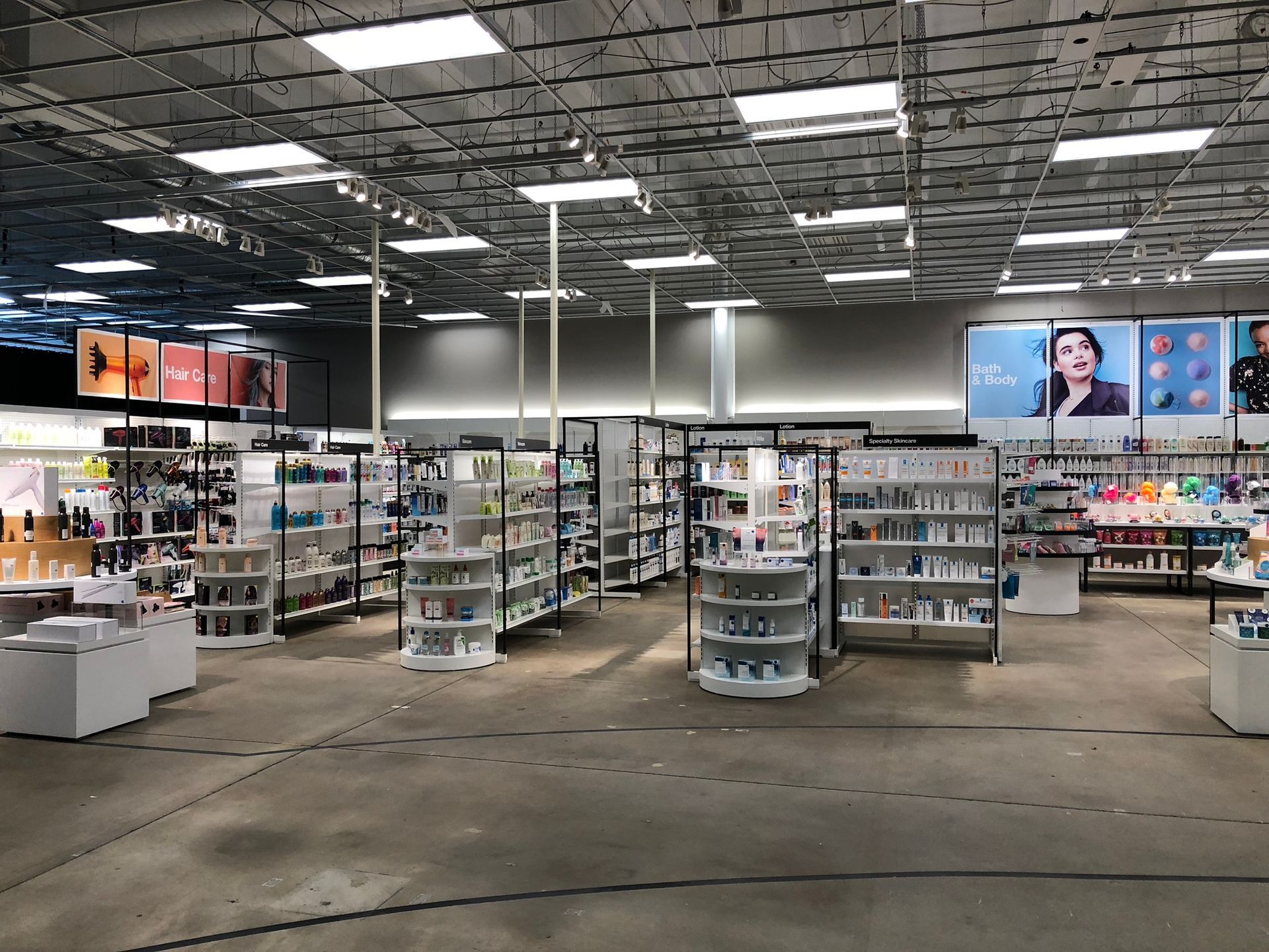 A beauty supply store interior with shelves of products and promotional posters.