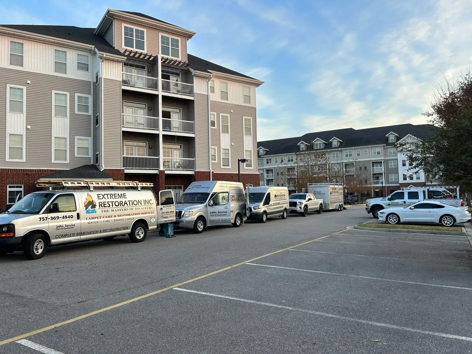 Vehicles parked in front of an apartment building.