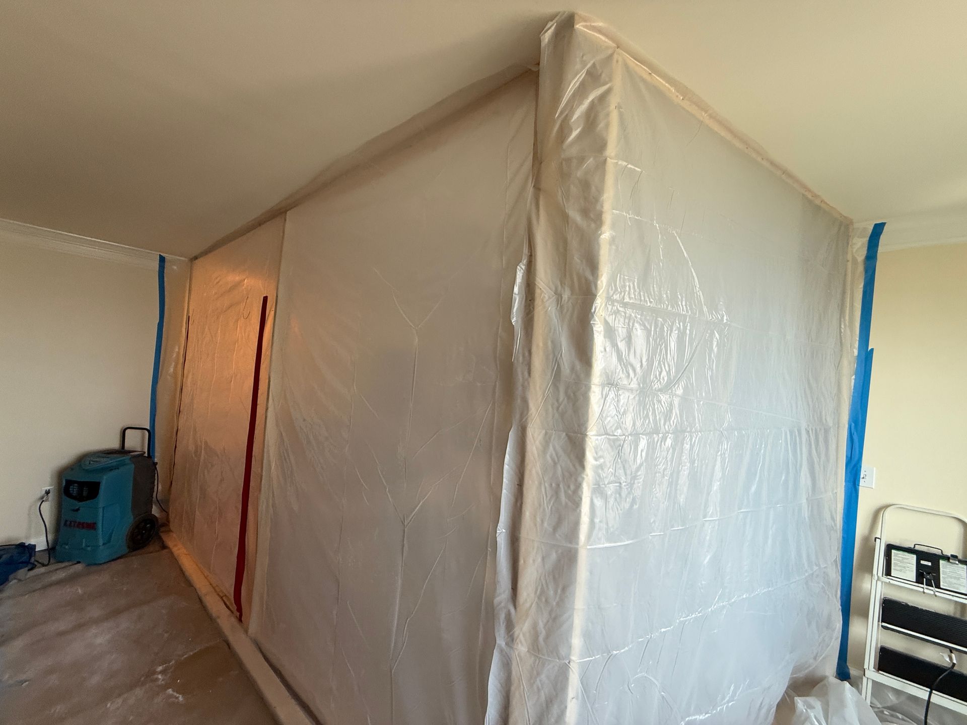 A temporary plastic barrier built in a room for construction or remediation.