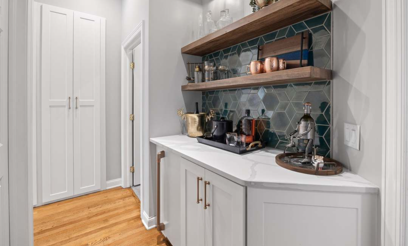 Modern hallway with white cabinets, wood floor, and a teal-tiled coffee bar shelf display