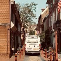 A white van is parked on the side of a narrow street.