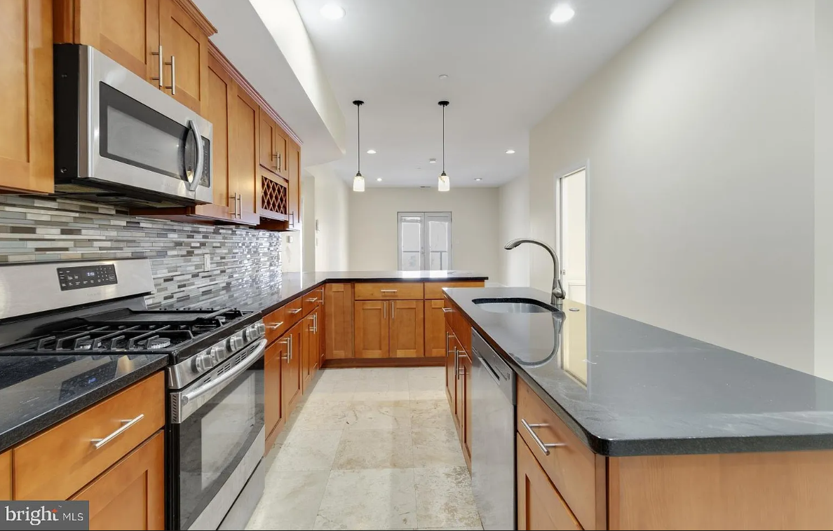 A kitchen with stainless steel appliances and wooden cabinets