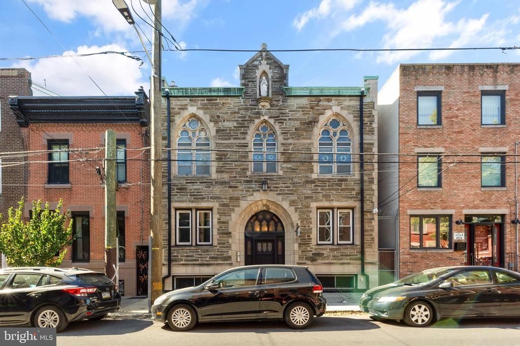 A row of cars are parked in front of a brick building