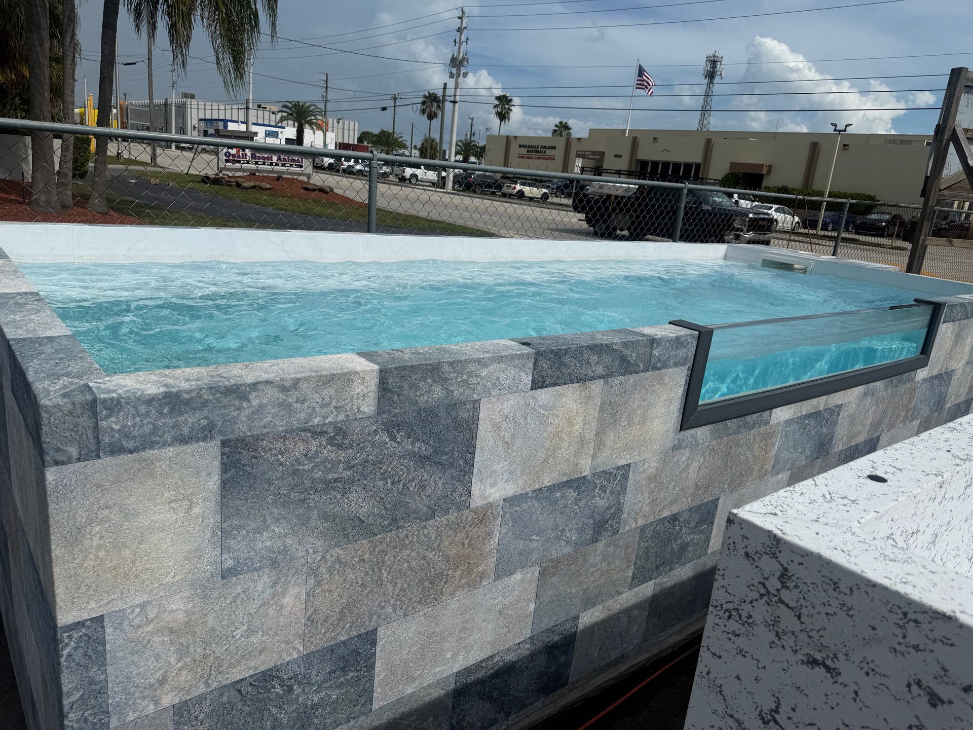 Blue-tiled spa pool with bubbling water beside a stone wall outdoors