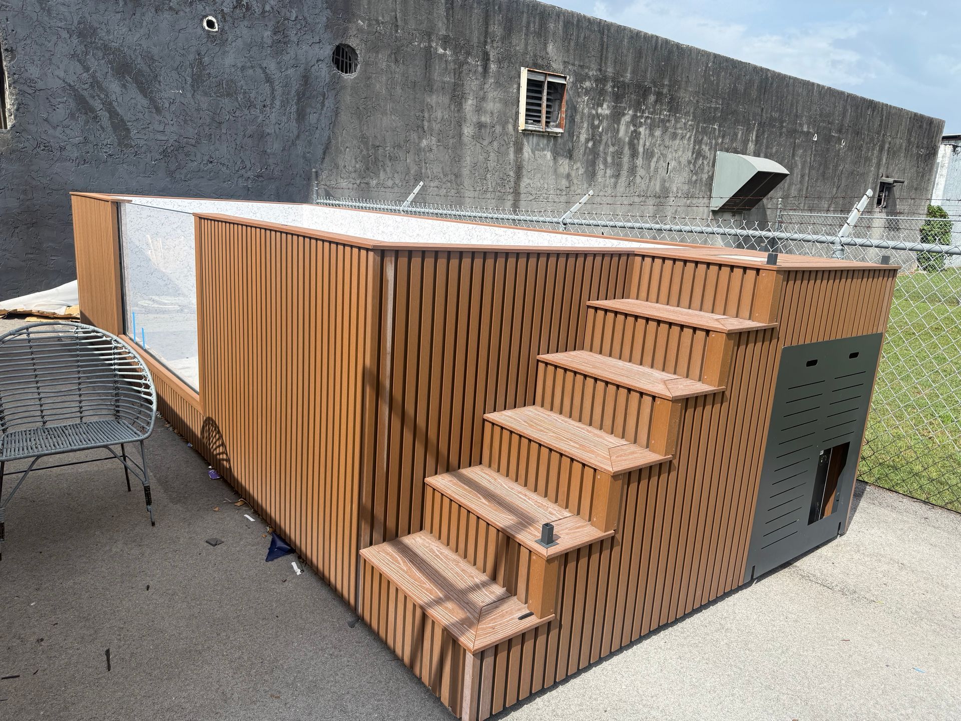 Wooden outdoor stair structure with perforated side panels on a rooftop or patio