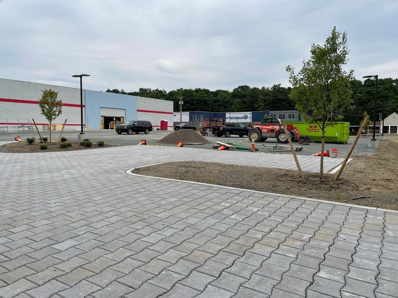 Construction site with a new paved parking lot in front of a large building.