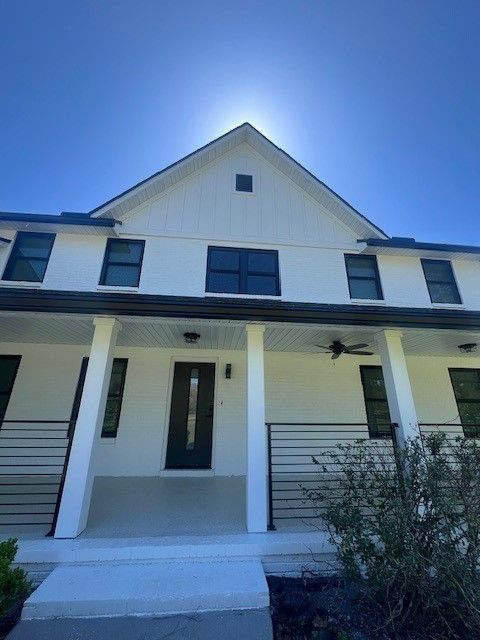 Archway leading to a playroom; white gate, toys, shelves filled with objects, light streaming in.