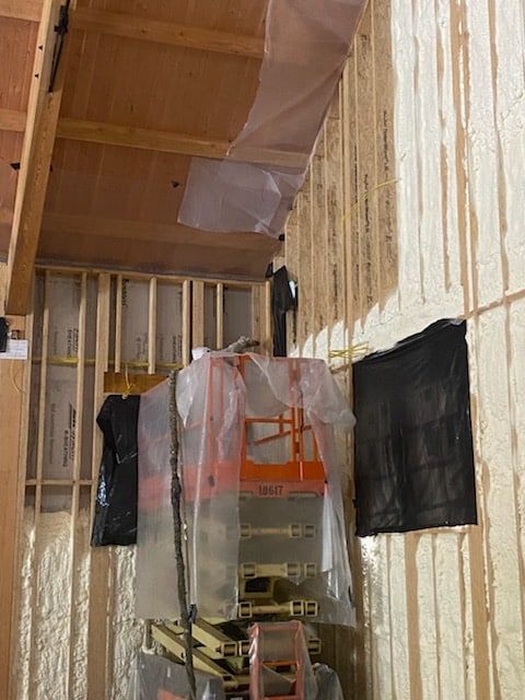 A ladder is sitting in a room with foam on the walls.