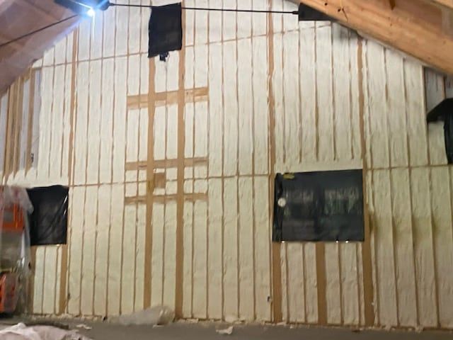 A room with a wall covered in insulation and a ceiling.