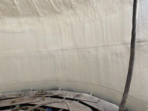A large concrete tank with a hose coming out of it.