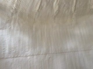 A close up of a piece of white fabric on a bed.