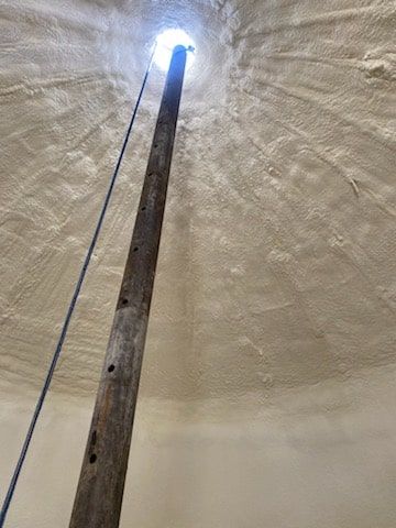 A wooden pole is hanging from the ceiling of a building.