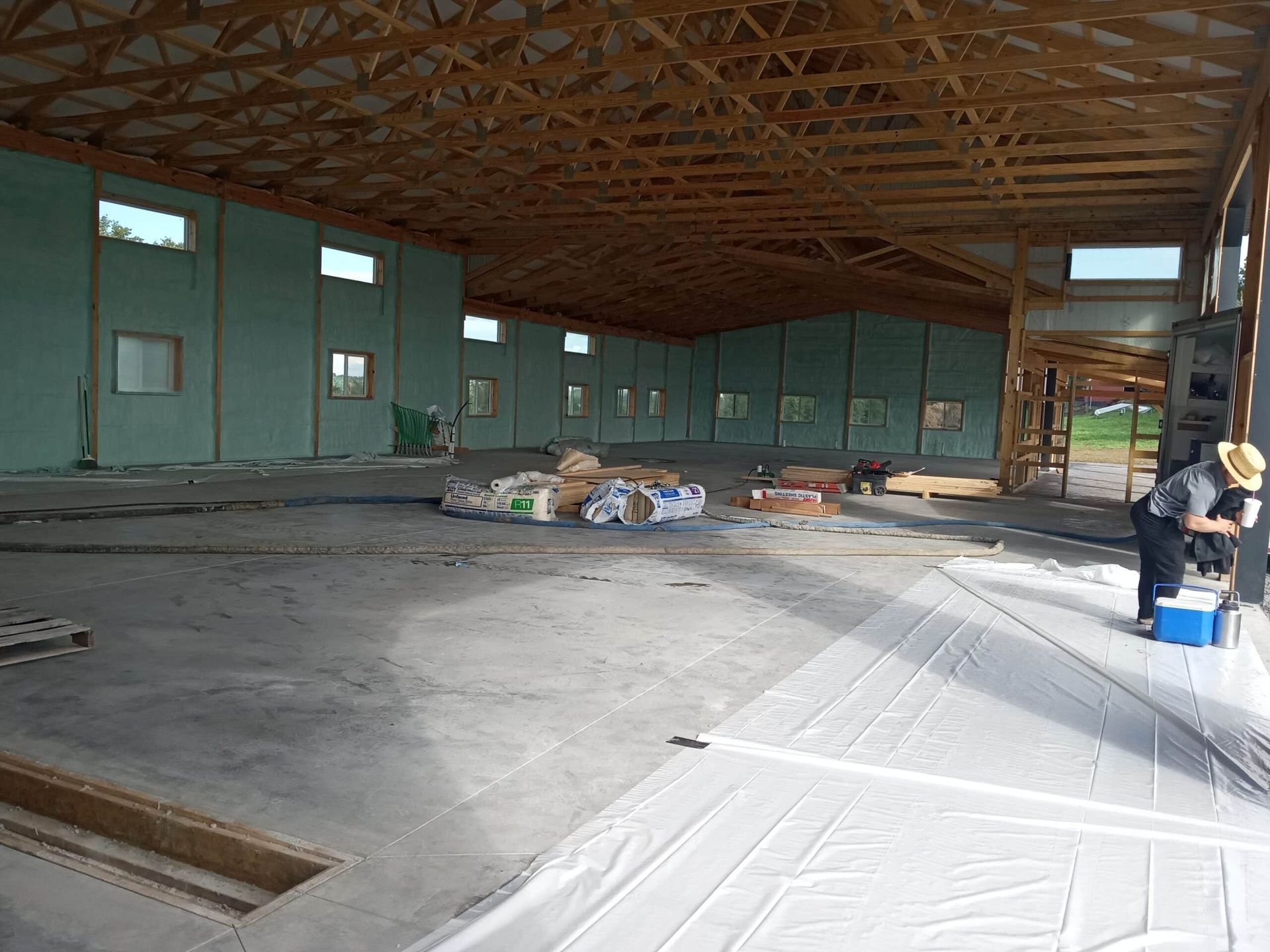 A man is standing in the middle of a large building under construction.