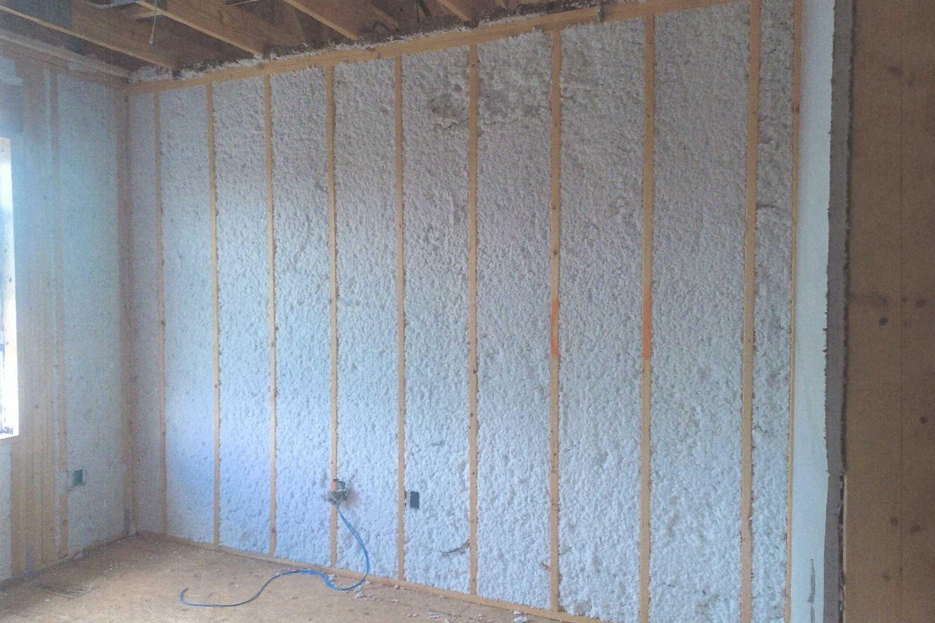 A room with a wall covered in insulation and wooden beams.