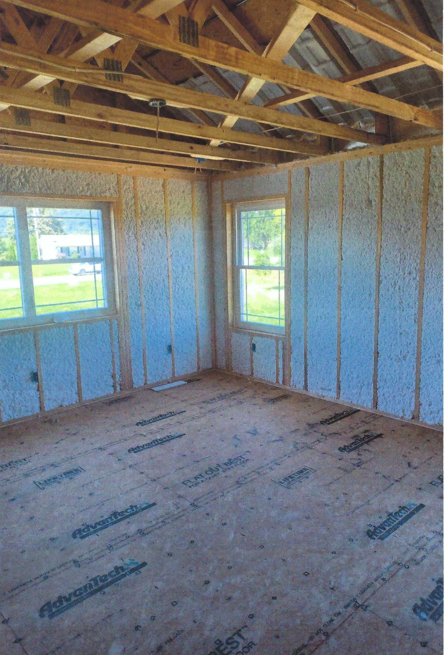 A room with a wooden ceiling and a lot of windows.