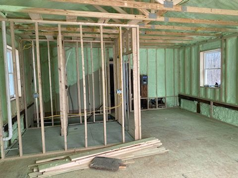 A room with a lot of wooden beams and foam insulation on the walls.