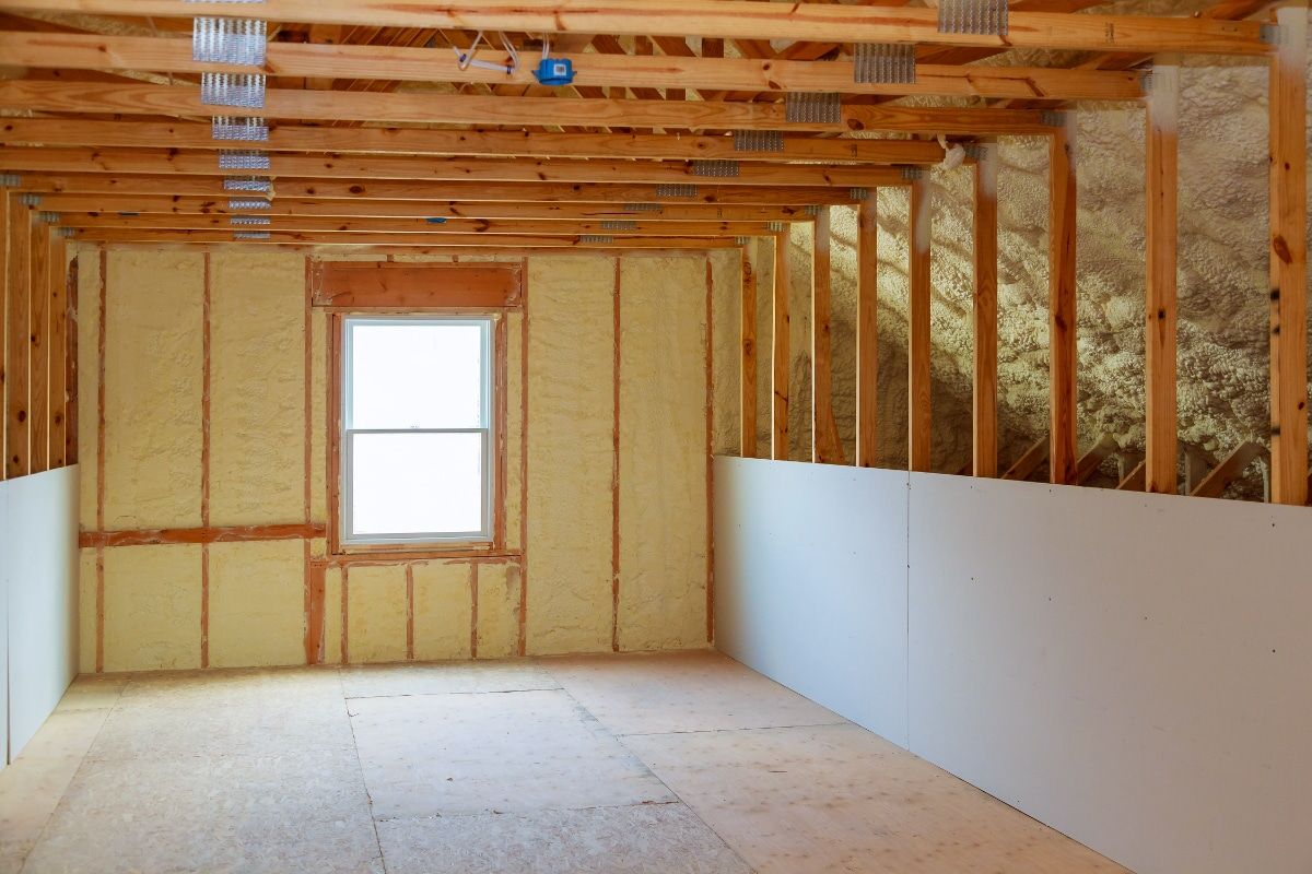 An empty room in a house under construction with a window.