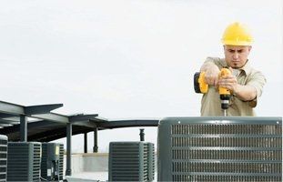 Technician wearing hard hat installing a cooling system