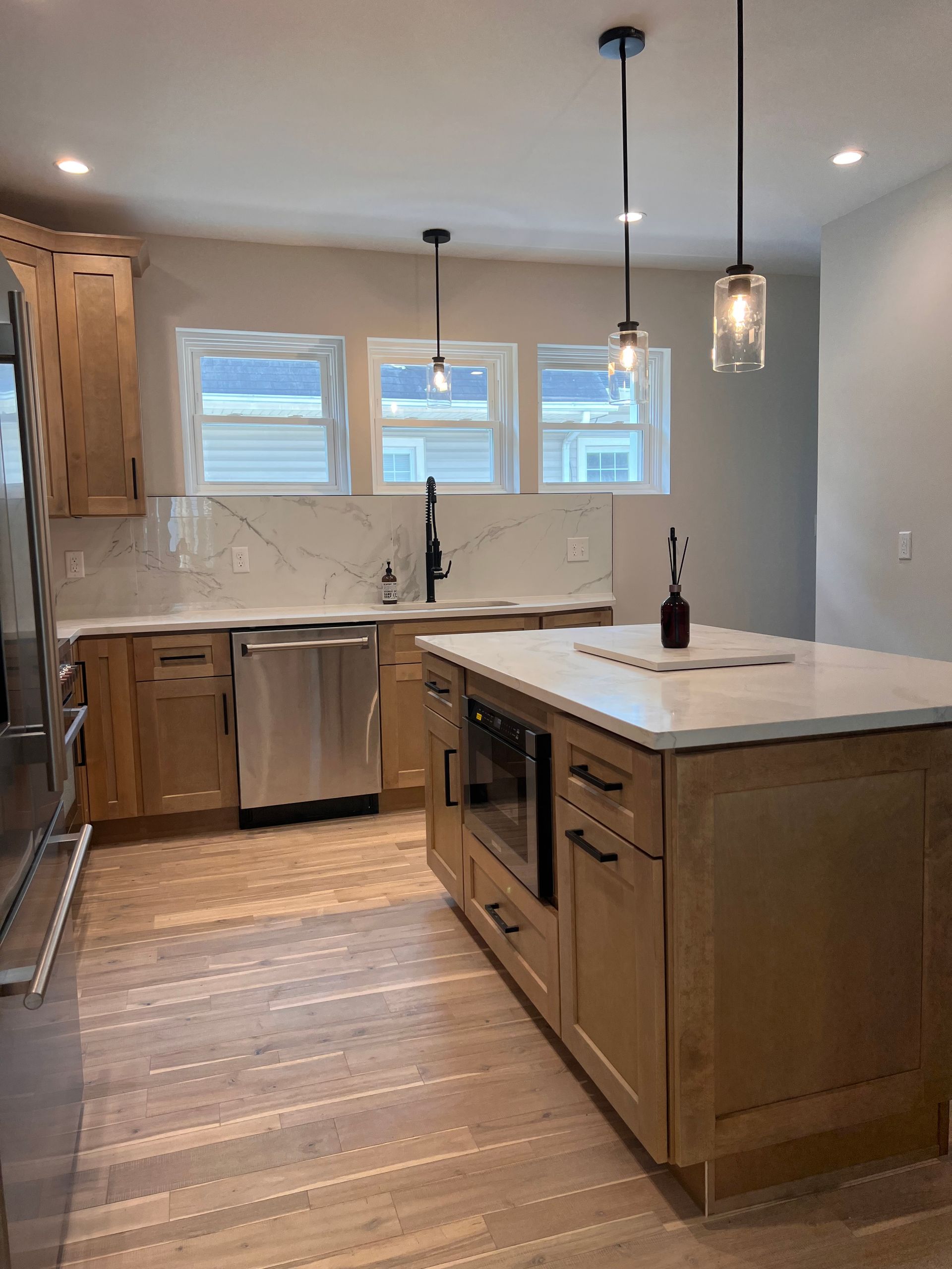 Newly renovated kitchen with wood cabinets, white countertops, and stainless steel appliances.