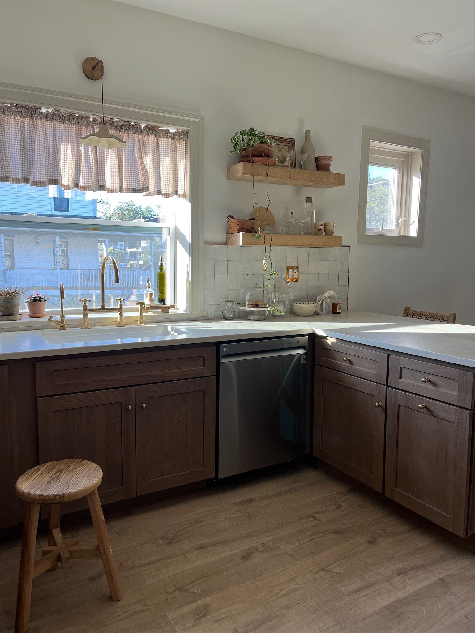 Kitchen with brown cabinets, stainless steel appliances, and wood shelves.