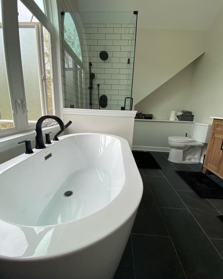 Modern white bathroom with a soaking tub, black fixtures, and a glass shower.