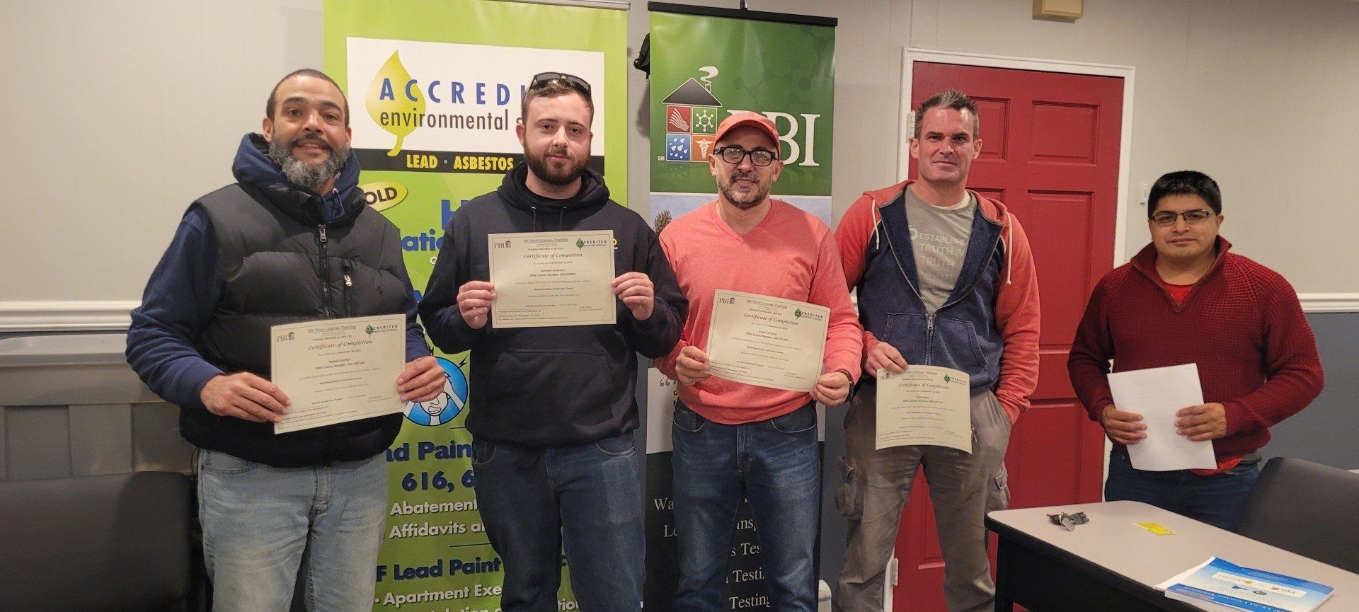 A group of men are standing next to each other holding certificates