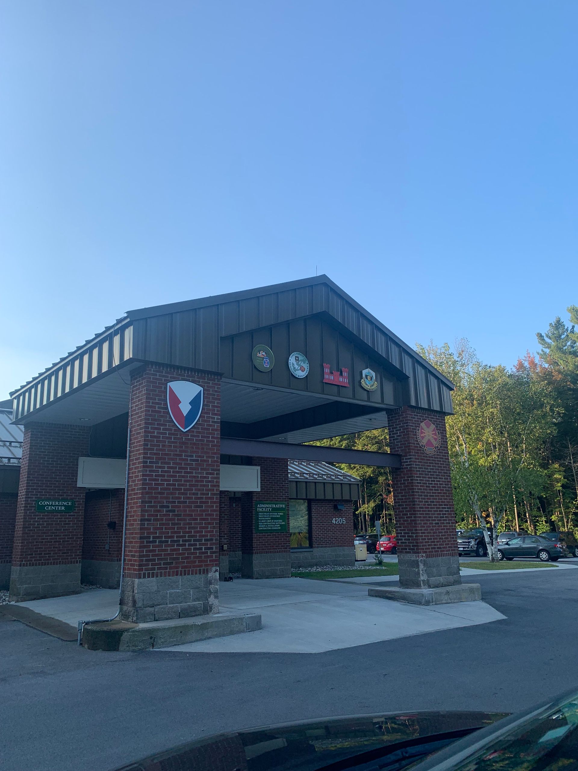 A brick building with a roof and a car parked in front of it