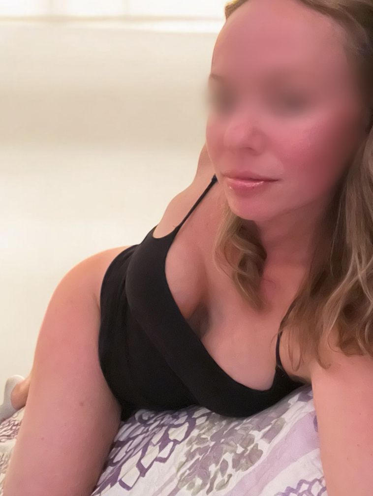 A woman is laying on a bed with her eyes closed