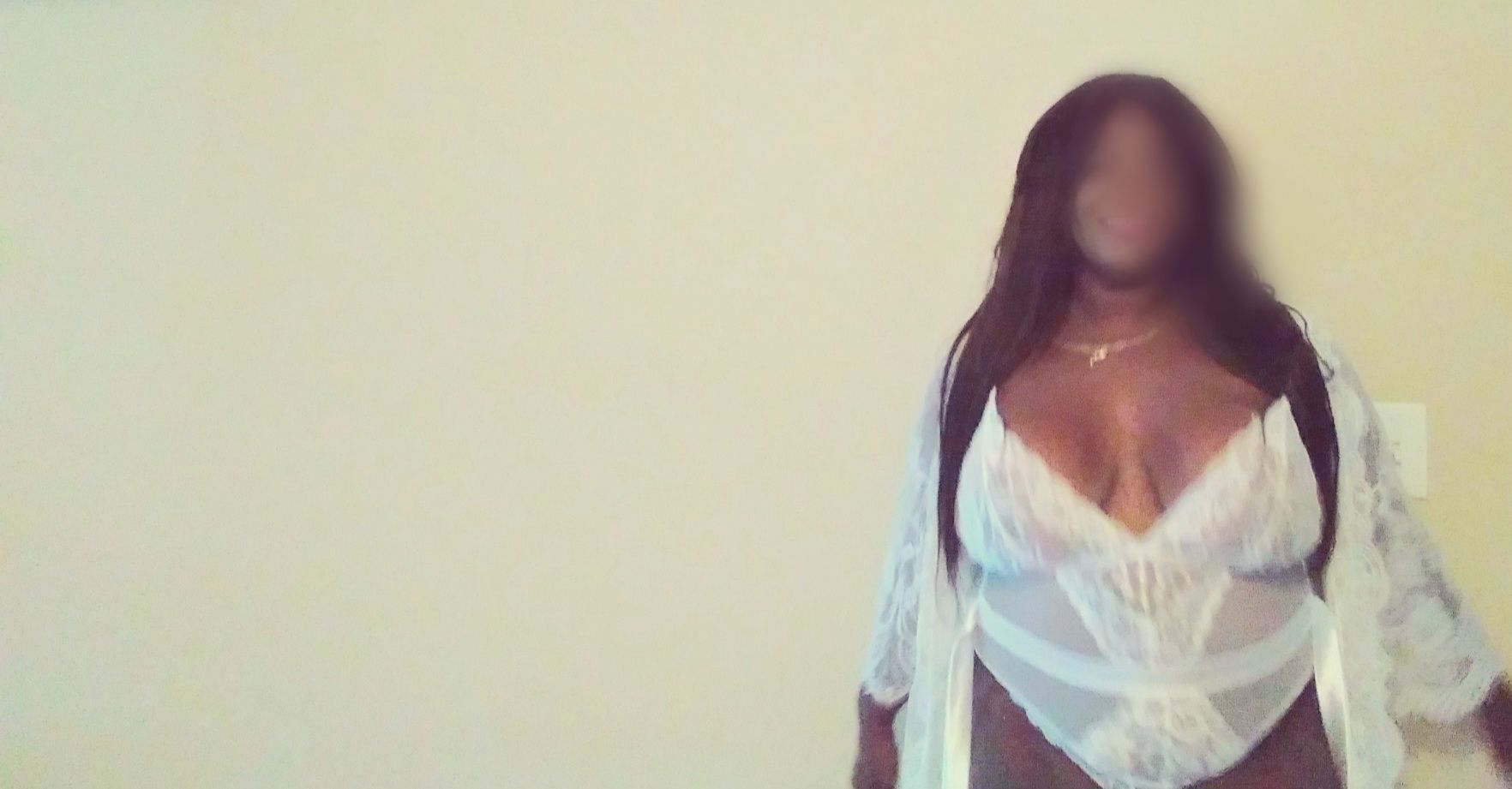 Woman in white lingerie and robe, standing indoors.