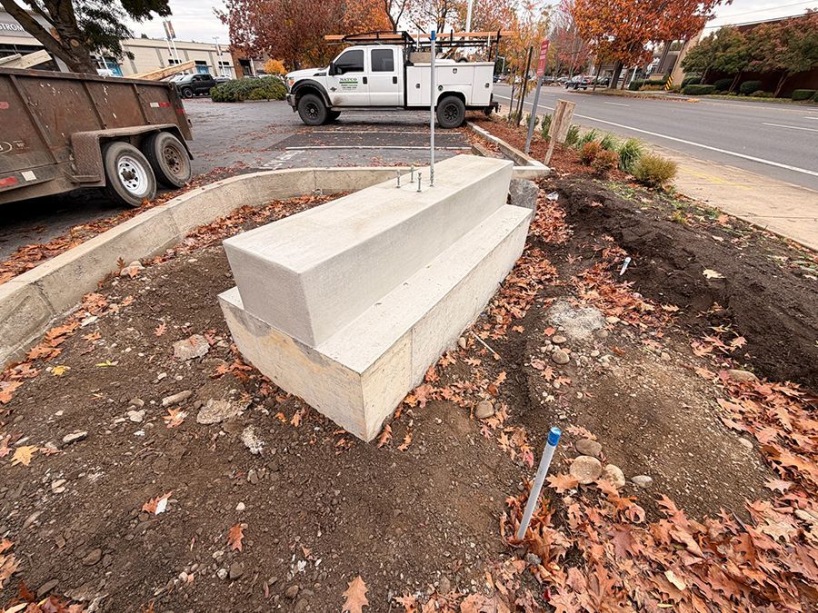 Concrete block structure in dirt, with truck and trailer visible, outdoors.
