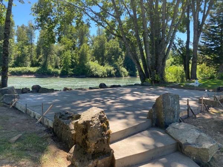Concrete platform with stone steps and river in background.
