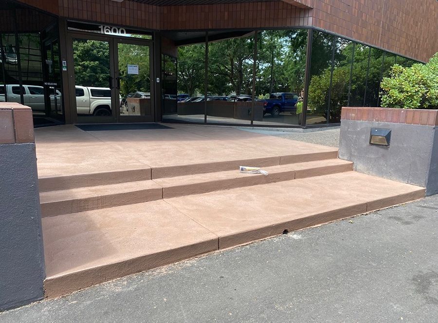 Concrete steps leading up to glass doors of a building.