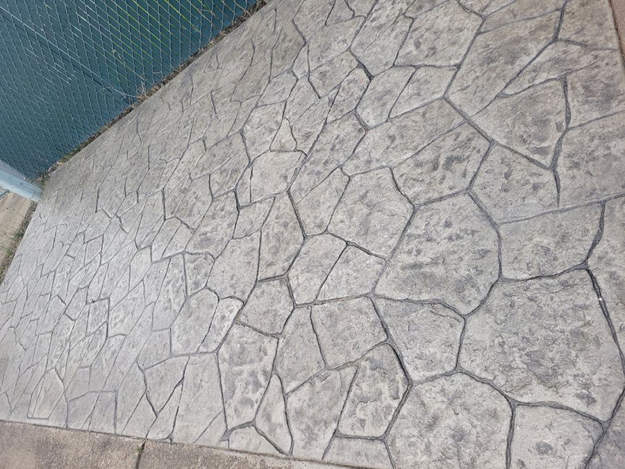 Stamped concrete patio with a gray stone pattern.