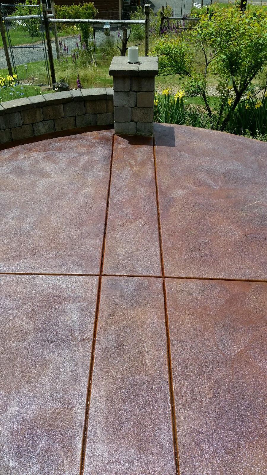 Stamped concrete patio with a chimney, brown and rust colors.