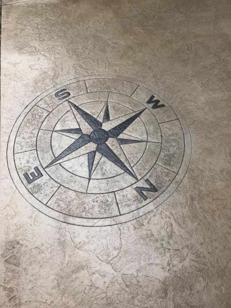 Compass rose design embedded in a textured, light brown surface.