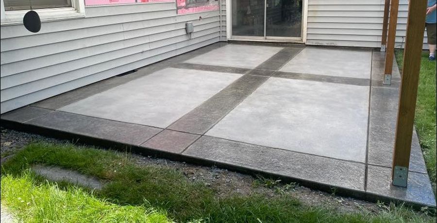 Concrete patio with light gray squares and dark gray border and cross design.