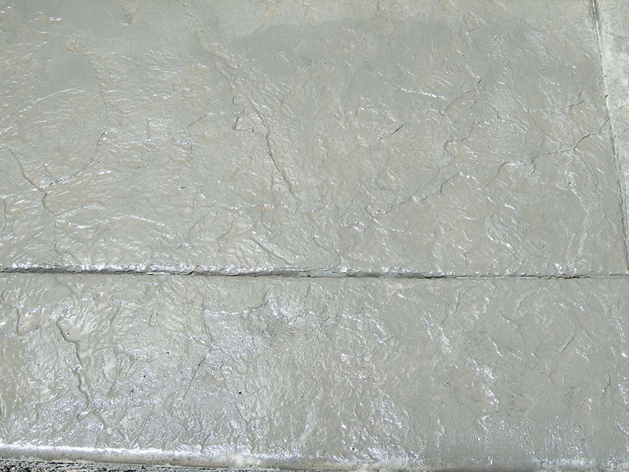 Gray, textured concrete surface with visible lines and cracks.