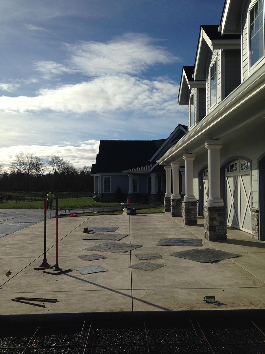 Concrete patio with house and cloudy sky background.