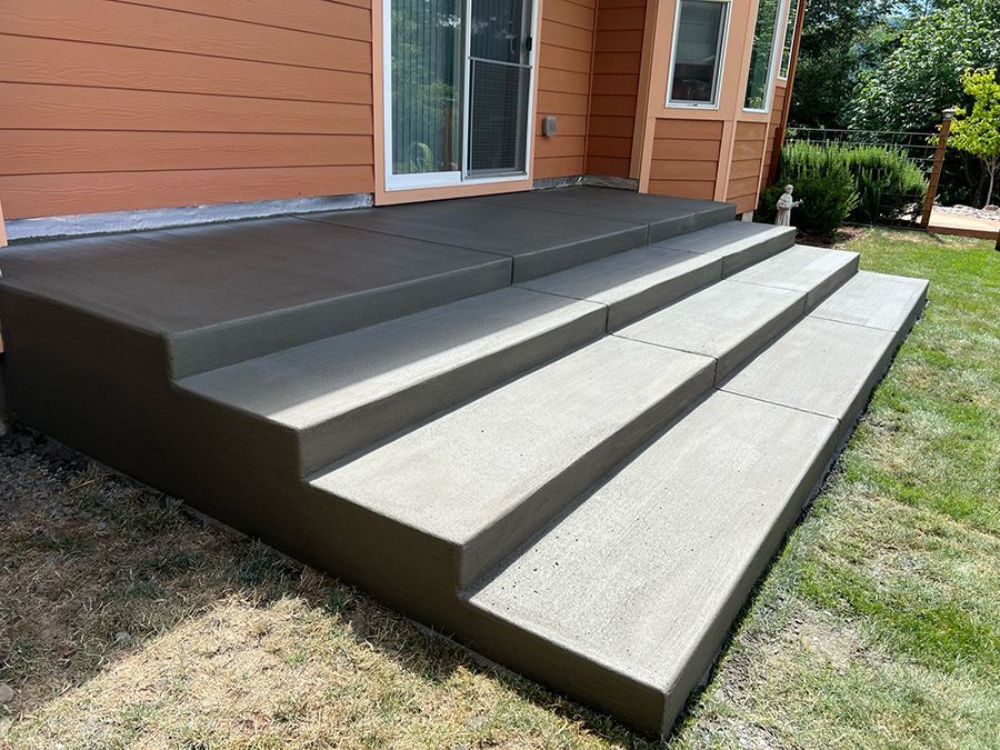 Concrete steps leading up to a house with a sliding glass door. Steps are gray.