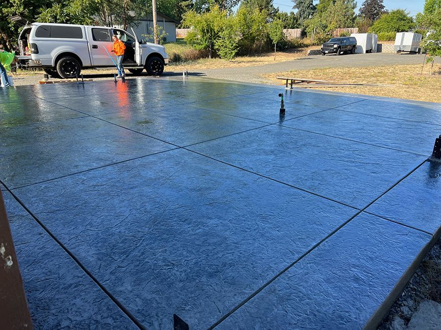 Freshly poured concrete patio with grid lines, a truck, and a person.