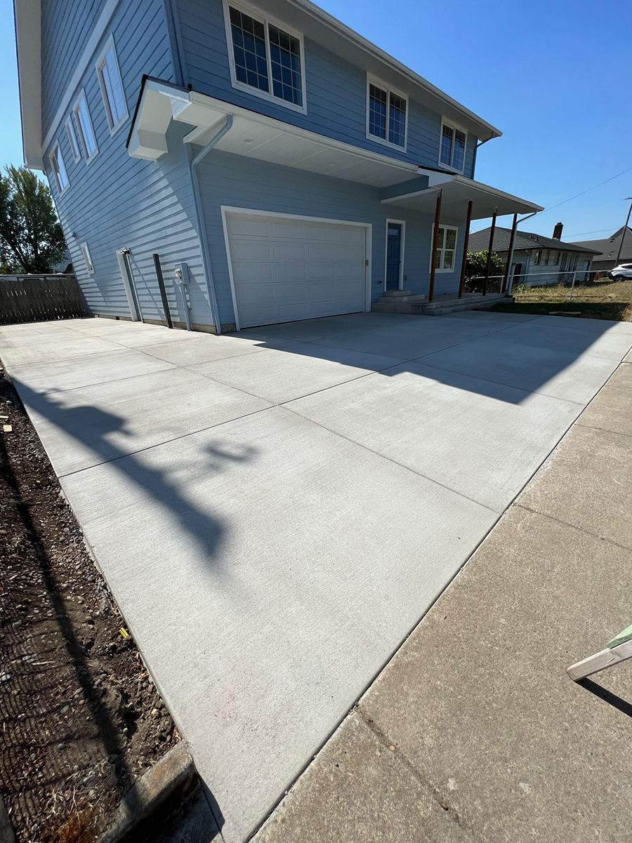 Light blue house with a new concrete driveway.
