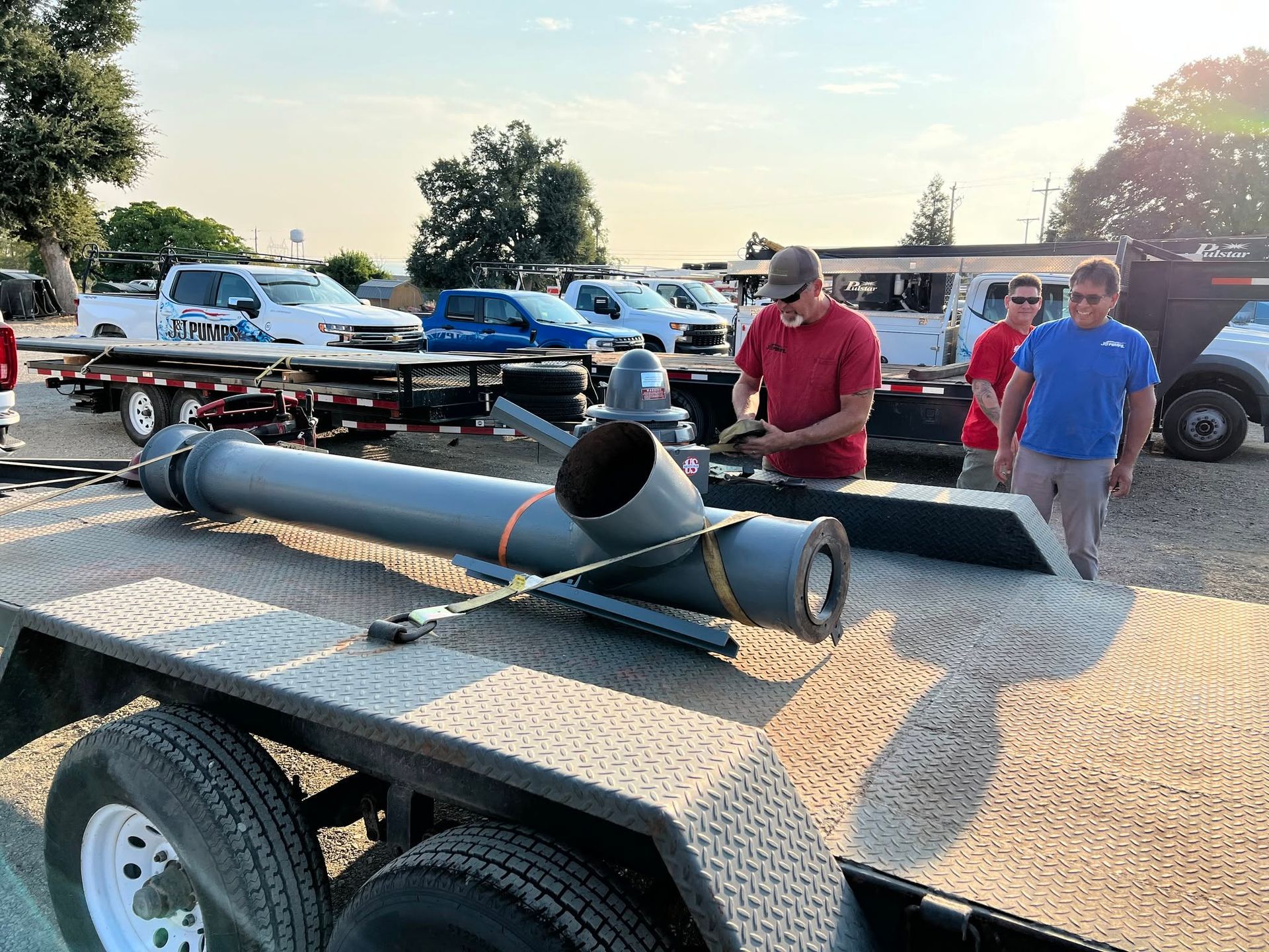 Large black rocket-like tube on a trailer at an outdoor car show, with two men standing nearby.