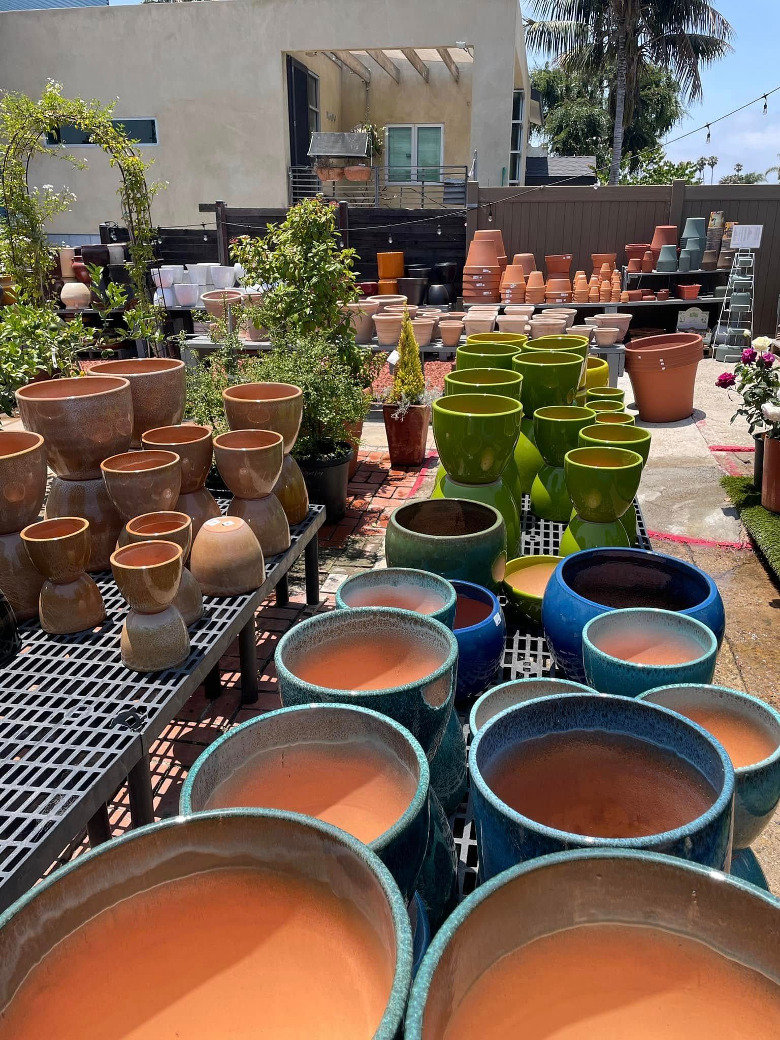 Outdoor display of various ceramic planters in an array of colors and sizes.